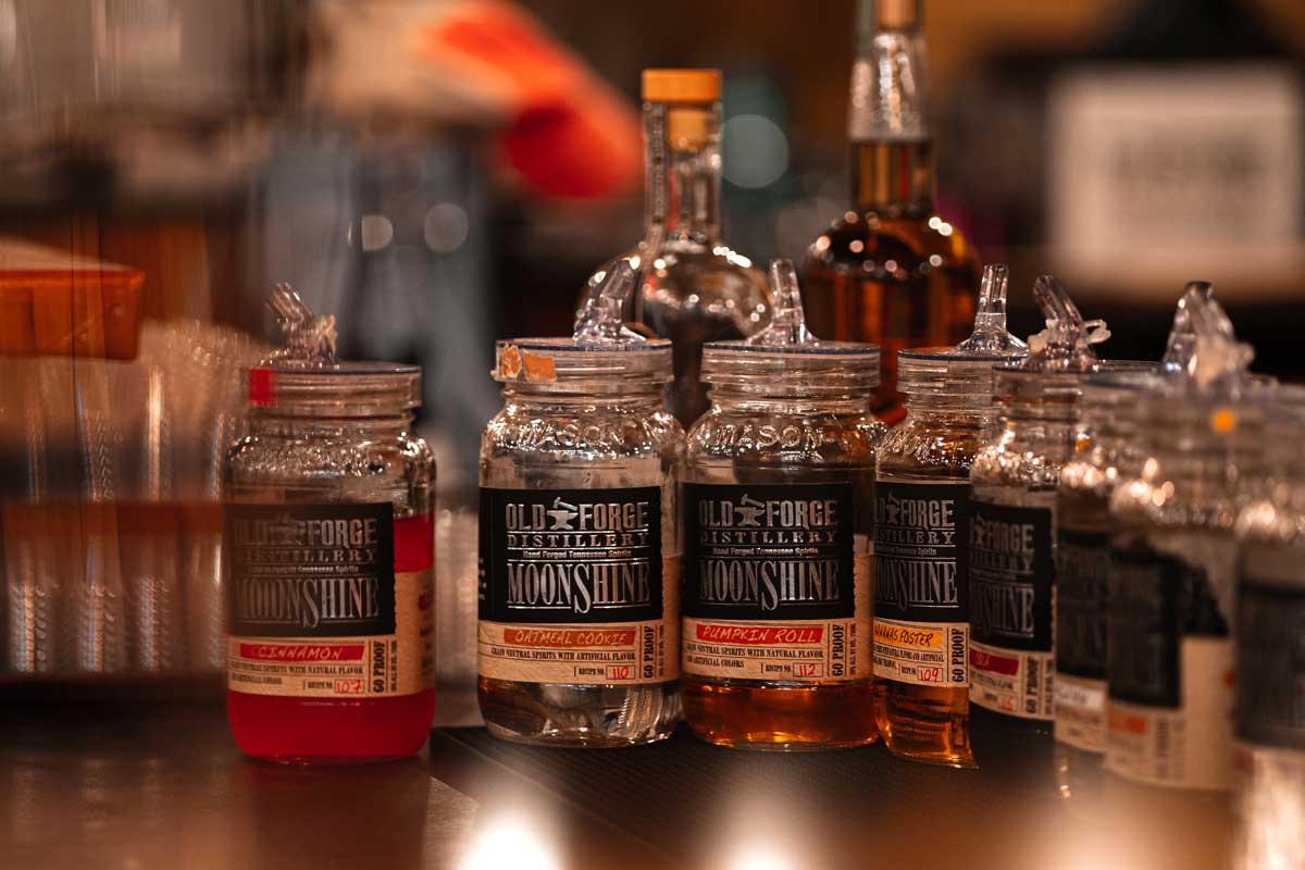 A row of bottles displaying moonshine varieties at Old Forge Distillery, one of the affordable things to do in Pigeon Forge.