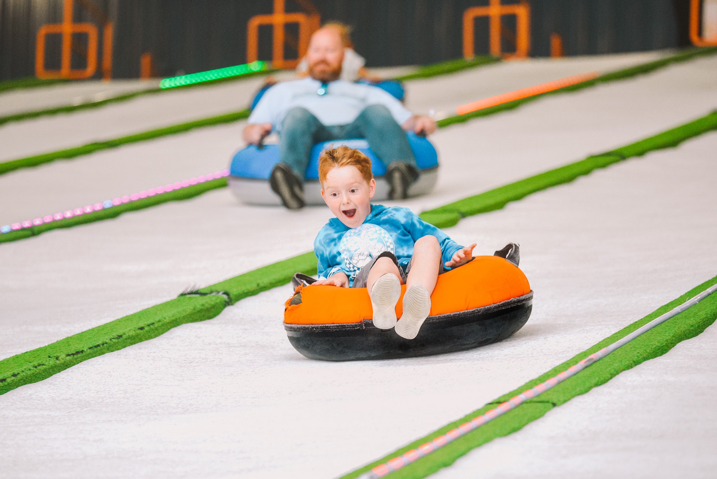 Indoor snow tubing track with riders sliding down, one of the most exciting indoor things to do in Pigeon Forge.
