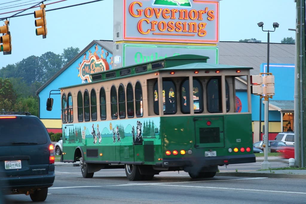 The famous Pigeon Forge trolley passes Governor's Crossing shopping center known for affordable local transportation.