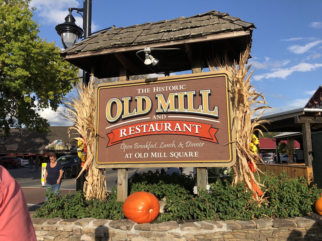Rustic sign for The Historic Old Mill Restaurant, decorated with corn stalks and pumpkins.
