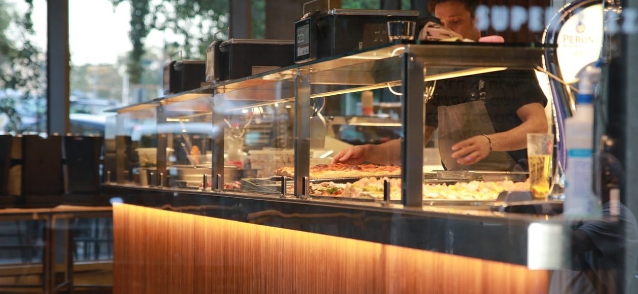 A chef loading up toppings on a pie at a pizza place in Pigeon Forge